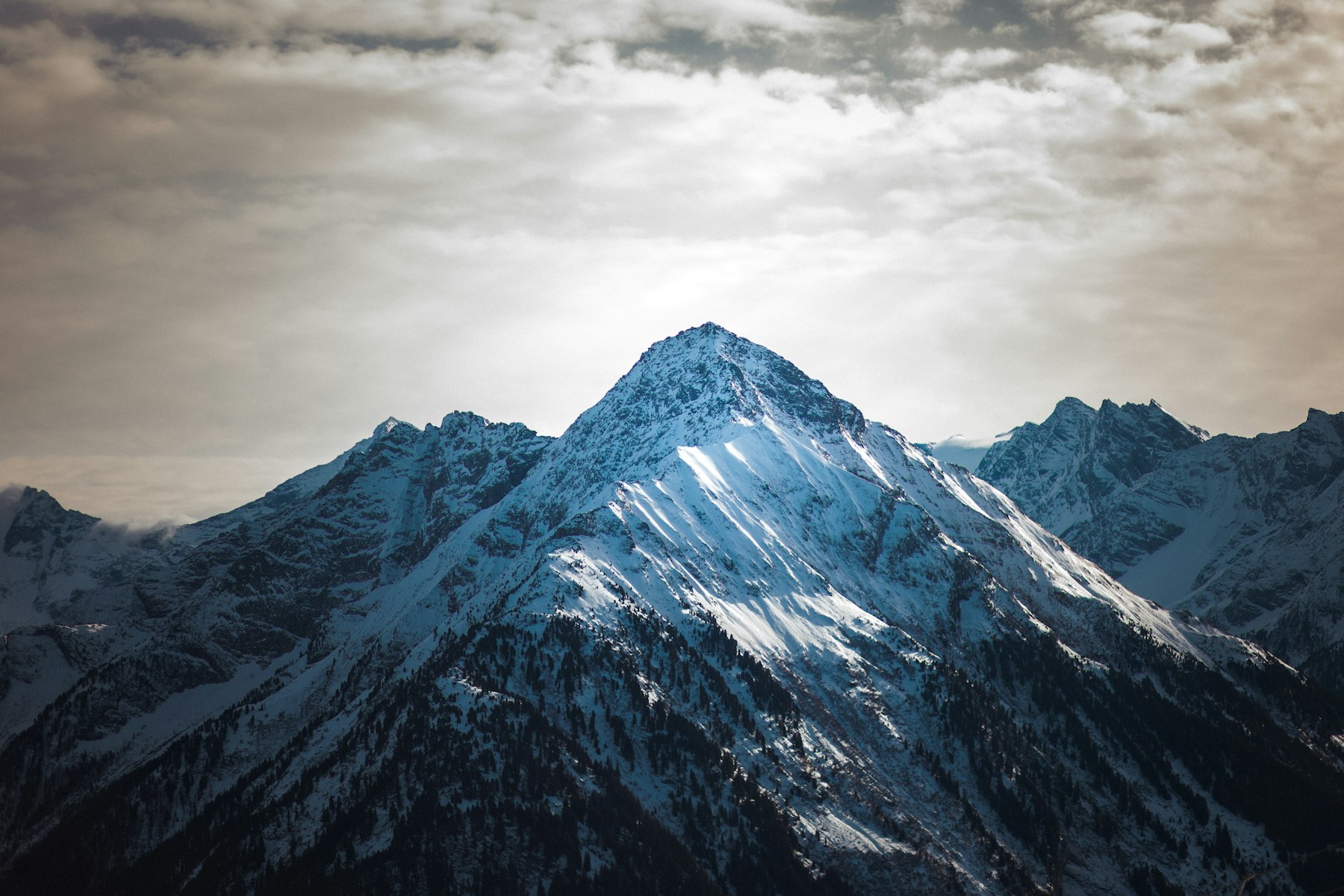 Cold blue snowy peaks under moody morning light