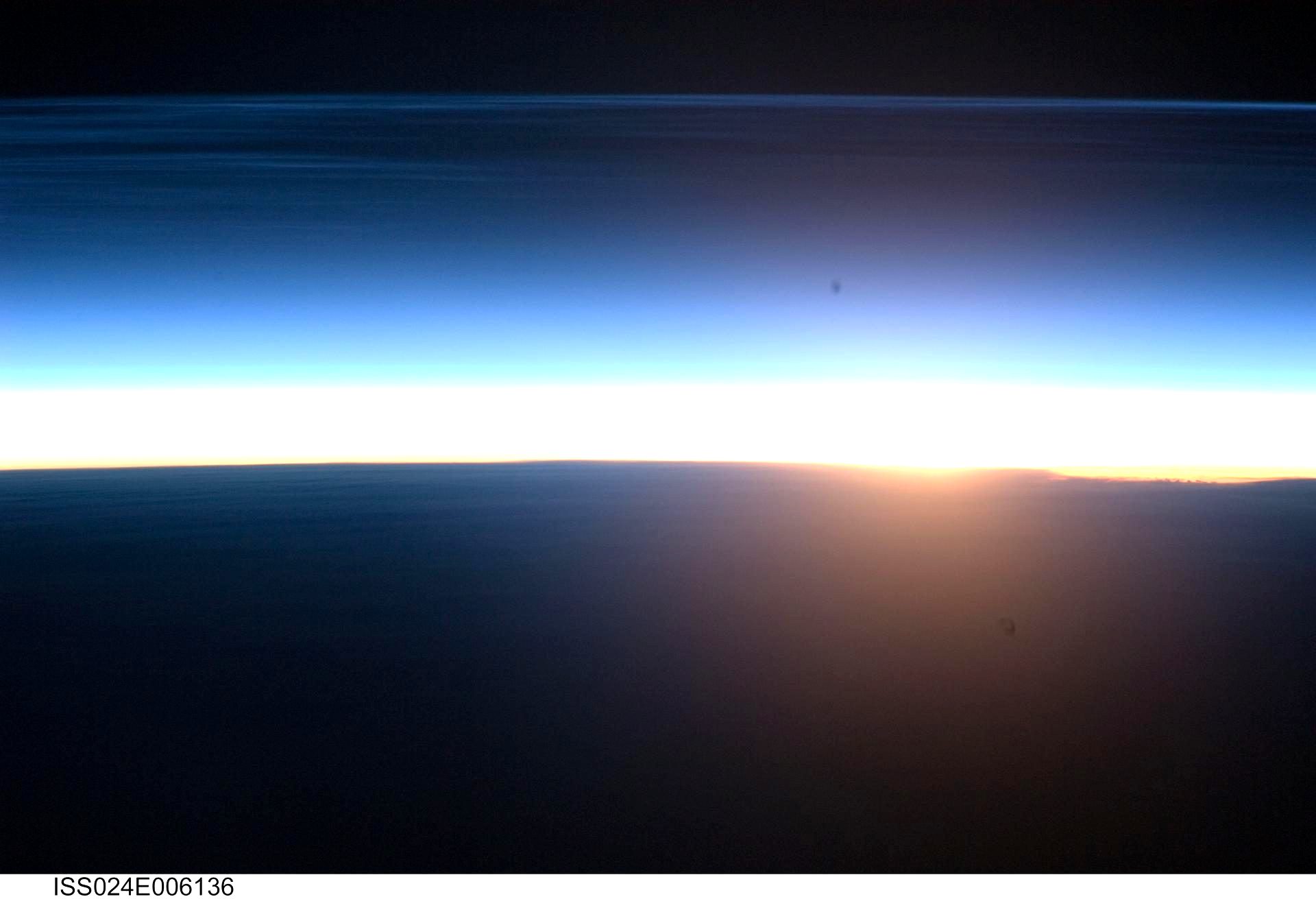 Polar mesospheric clouds lit by an orbital sunrise
