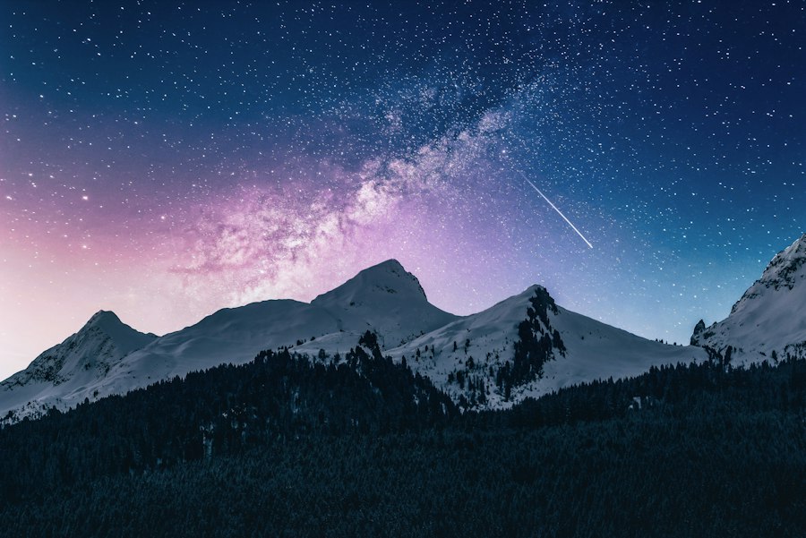 Stars over snow-covered peaks at night