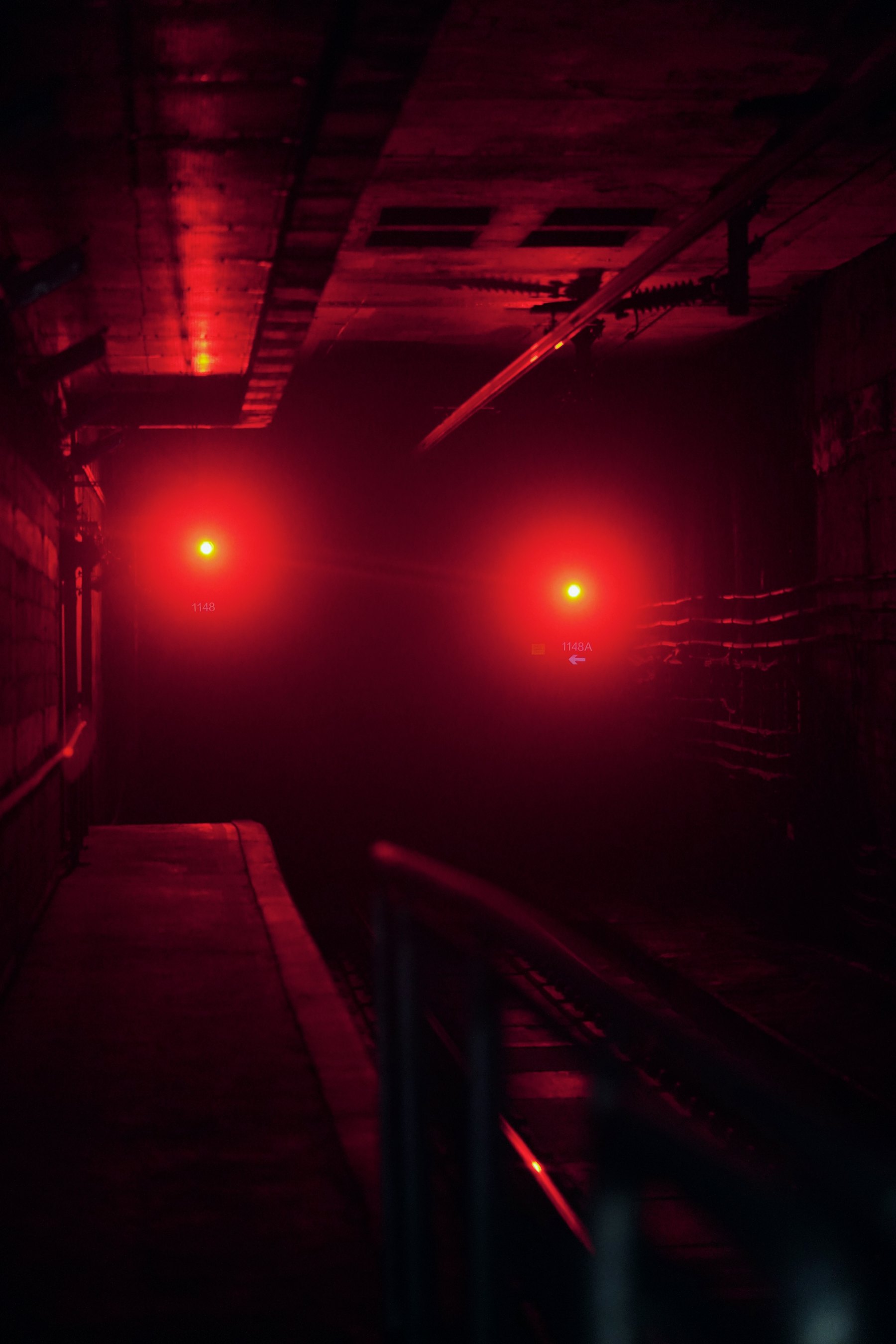 Red signal lights glowing in the dark along a railway at night