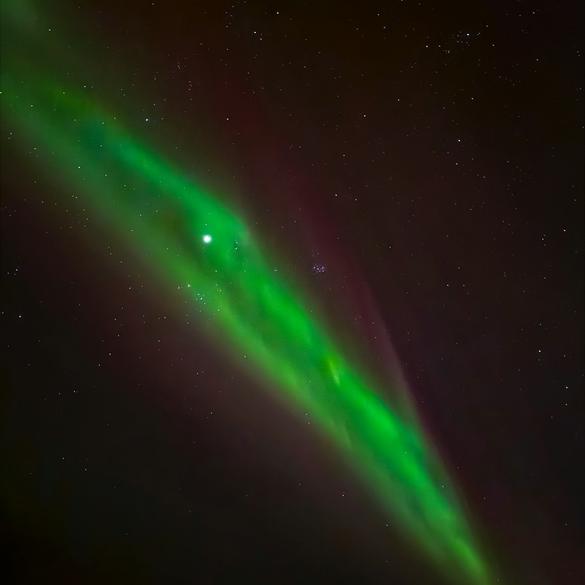 Green aurora band across the night sky