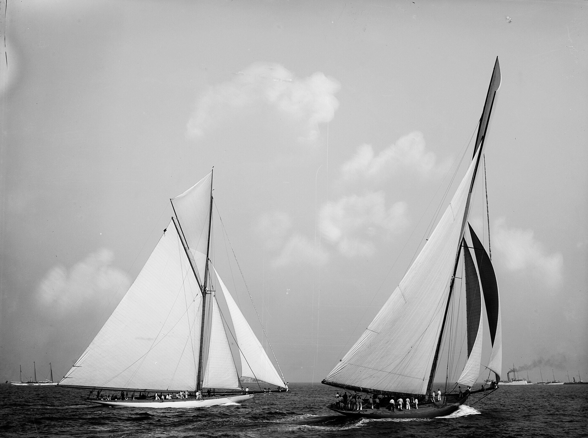 Two racing yachts heeling under full sail in a building sea, black and white photograph, 1899